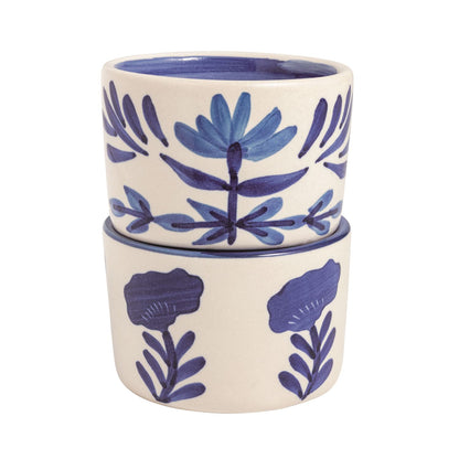 Set of two ceramic cups with blue floral patterns on a white background.