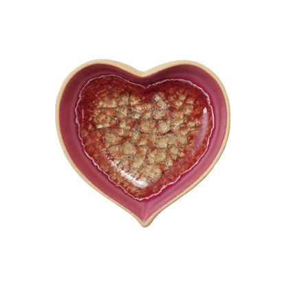 Heart-shaped ceramic dish with a red interior and beige exterior on a white background