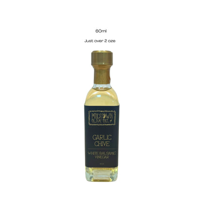 Bottle of Garlic Chive White Balsamic Vinegar with a gold cap on a white background