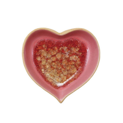 Heart-shaped pink ceramic dish with a textured red interior on a white background