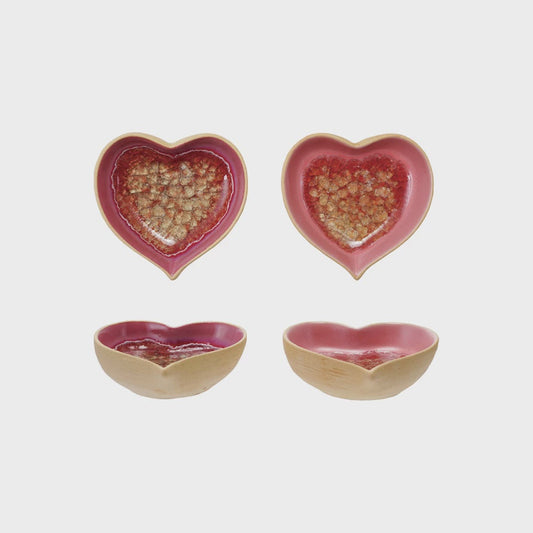 Four heart-shaped ceramic bowls on a light gray background