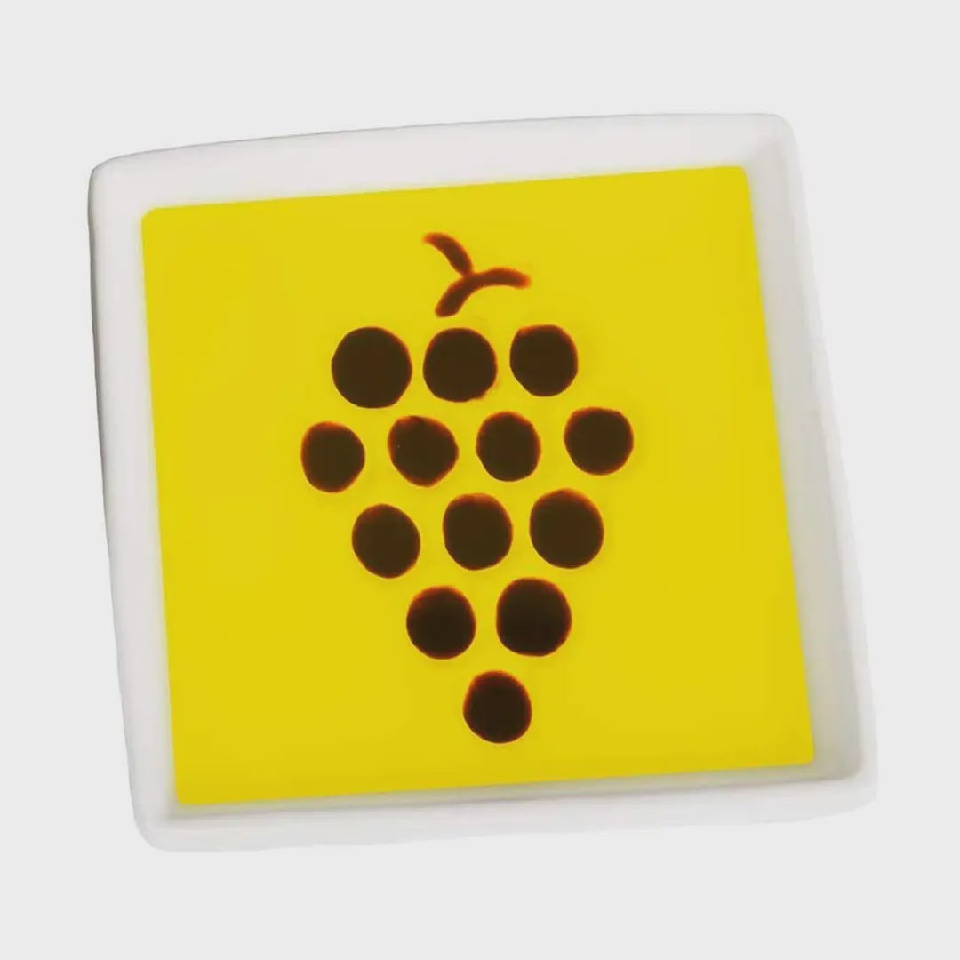 Square tile with a yellow background and brown grapevine design on a white background